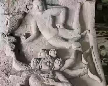 PXL_20241025_025612706 In the left cave, Kumara sitting on a peacock was carved on the western side of the door, 5 heads 6 arms, kid's appearance, curling hair, holding the sun and...